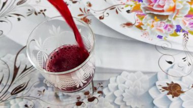 Canlı pancar suyu bardağa doluyor. Taze, zengin ve koyu renklerle doluyor.