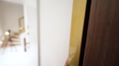 Altın ışık parlak bir kapıdan süzülüyor, yumuşak gölgeler bırakıyor ve içinde huzur parlıyor.