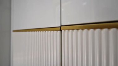 Parlak altın aksanlı, desenli gardırop. Rafine kontrast, zamansız karmaşıklıkla buluşuyor.