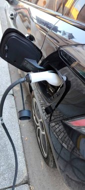 Modern bir şarj istasyonunda elektrikli bir arabayı şarj etmek. Yüksek kalite fotoğraf