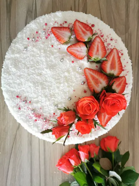 Beyaz kremalı kek, taze sulu çilekler ve narin güllerle süslenmiş. Yüksek kalite fotoğraf