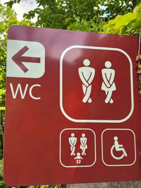 Umumi tuvalet tabelası engelli bir erkek, bir kadın ve çocuklu bir ebeveyni tasvir eder..