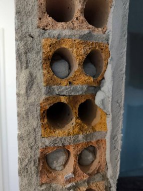 Kısmen alçıyla kaplı eski bir tuğla duvarın parçası. Yuvarlak delikli tuğlalar, bazılarında dolgu malzemesi kalıntıları görülebilir. İnşaat, onarım ve mimari konuları göstermek için