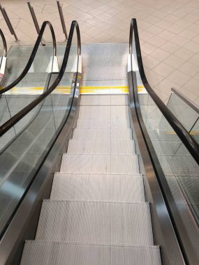 Temiz, modern metal ve cam yapısını gösteren boş bir yürüyen merdivenin genel görünümü.