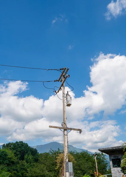 The electric pole and electric transformer with blue sky cloud.