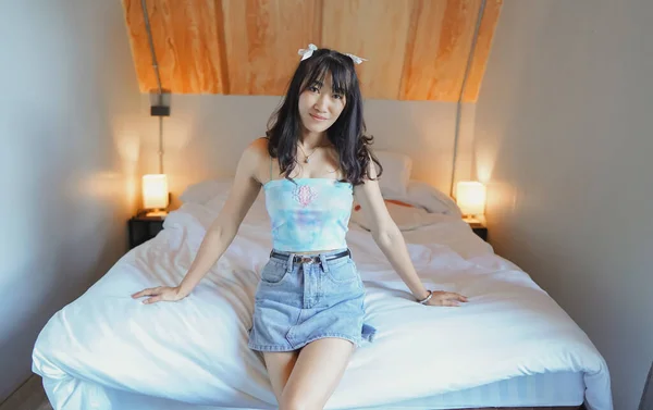 性感的亚洲女人穿着性感的衣服坐在床上 — 图库照片
