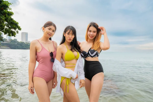 アジアの3人の若いですセクシー女性身に着けていますビキニ海のビーチでプレイ — ストック写真