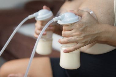 Annem iki göğsünü de pompalıyor. Otomatik pompa makinesiyle. Annelik ve Çocuk Sağlığı Konsepti.