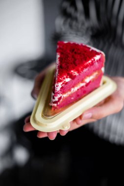 Bir parça kek tutan kadın.