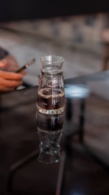 Bardakta kahve, ahşap bir masada buz.