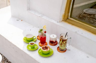 A photo of a group of drinks from a caf menu, featuring a variety of beverages such as soda and coffee, arranged beautifully on a rustic wooden table with a cozy caf backdrop. clipart