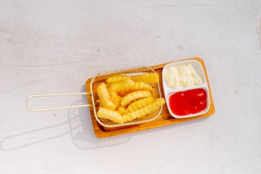 Tahta arka planda ketçaplı kızarmış patates.