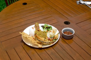 Kızarmış yumurtalı tavuk bifteği, ahşap bir tahtada ızgara et ve sebze..