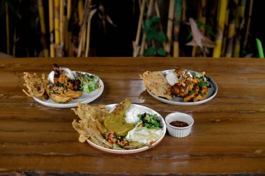 Tavuk kanadı, pilav, kızarmış patates ve salata.