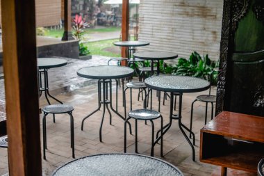 Restoranda sandalye ve masa olan boş bir sehpa.