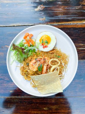 Ahşap arka planda deniz mahsullü spagetti.