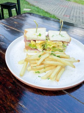 Tahta tabakta kızarmış yumurta ve peynirli sandviç..