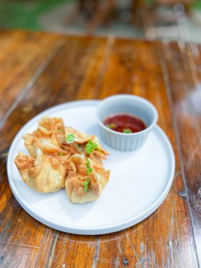 Tahta masada soslu kızarmış hamur köftesi.