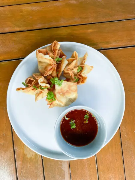 Sebzeli kızarmış tavuk kanadı ve beyaz tabakta sos.