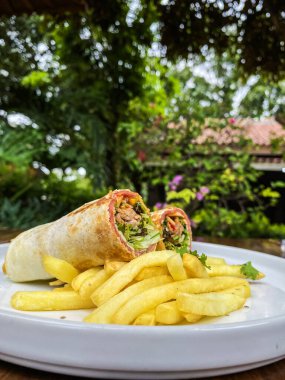 Masada soslu lezzetli bir patates kızartmasının yakın plan çekimi.