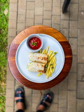 Sebzeli ızgara tavuk biftek ve ahşap masada patates kızartması.