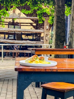 Bir bardak şarap ve bir fincan kahveyle bir masanın dikey görüntüsü.