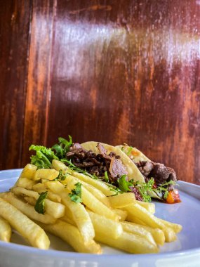 Biftek ve sebzeli patates kızartması.