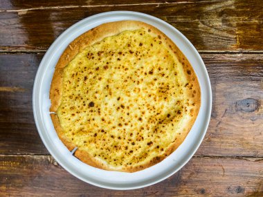 Ev yapımı pizza beyaz bir plaka üzerinde.