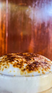 Krem şantili ve bir bardak kremalı lezzetli bir pastanın dikey yakın çekimi.