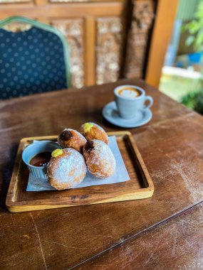 Kahvaltı, kahve ve kruvasan ile ahşap bir masada..