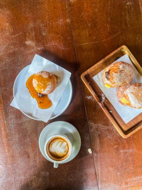 Kahveli taze ekmek ve ahşap bir masada kruvasan..