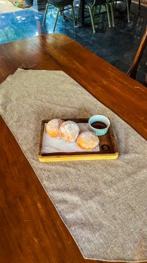 Tahta bir masanın üzerinde beyaz bir tabakla lezzetli bir pastanın yakın çekimi.