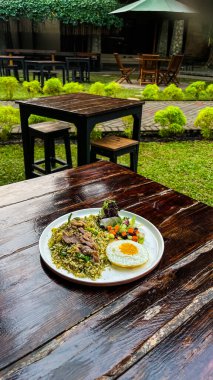 Kızarmış yumurta ve pirinçle servis edilen biftek..