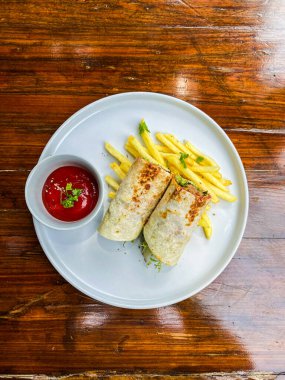 Tahta tabakta kızarmış tavuklu patates kızartması.