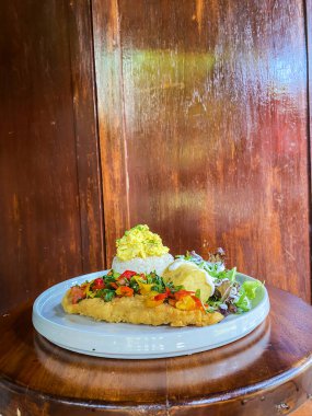 Tahta tabakta kızarmış balık ve sebze.