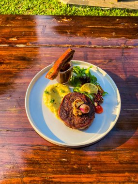 Kızarmış patatesli biftek, soğan ve sarımsak, kızarmış patates, bir tabakta, beyaz ahşap arka planda, restoran konsepti