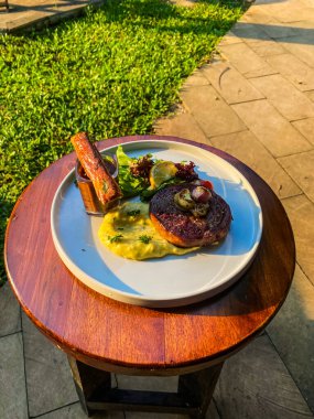 Ahşap masada ızgara biftek ve sebze.