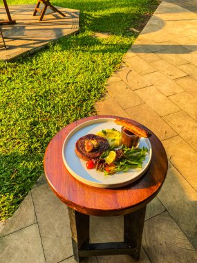 Masanın üzerine sebzeli ızgara biftek.