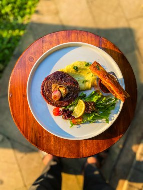 Masanın üstündeki kafede ızgara et ve sebze.