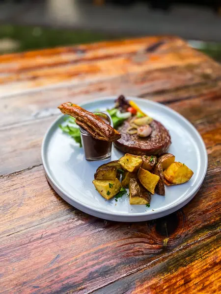 Kızarmış domuz, sebze salatası ve patates.