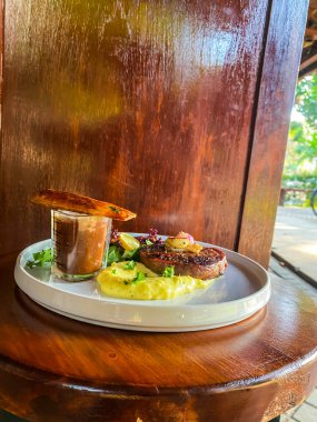 Tahta masada sebzeli ızgara tavuğun dikey görüntüsü.