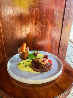 Soslu ve sebzeli lezzetli bir bifteğin yüksek açılı çekimi.