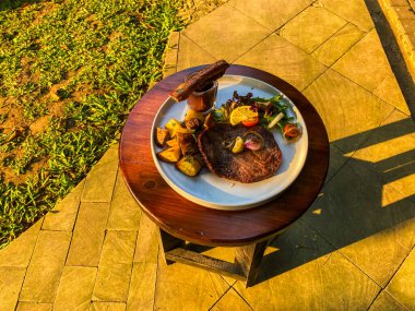 Tahta bir masada biftek ve sebze.