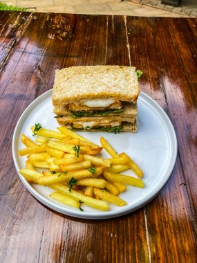 Tahta tabakta kızarmış tavuklu sandviç.