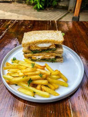 Patates kızartmalı Fransız tostu, kızarmış balık, peynir ve taze domates. sağlıklı yiyecekler