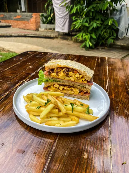 Tahtada patates kızartması ve ızgara tavuklu sandviç.