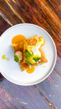 Tahta arka planda peynirli ve soslu lezzetli sahanda yumurta.