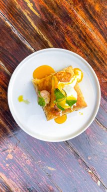 Portakal dilimi ve nane yapraklı bir yumurtanın dikey görüntüsü.