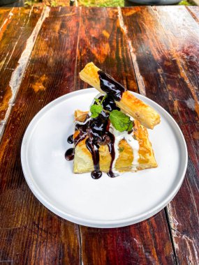 Çikolatalı gözleme ve siyah tabakta fındık.