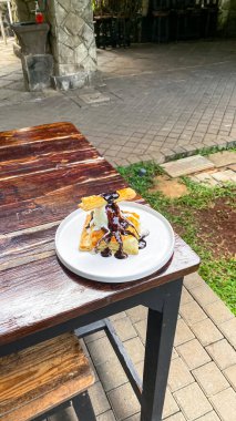 Dondurmalı kek ve ahşap masada çikolata sosu.